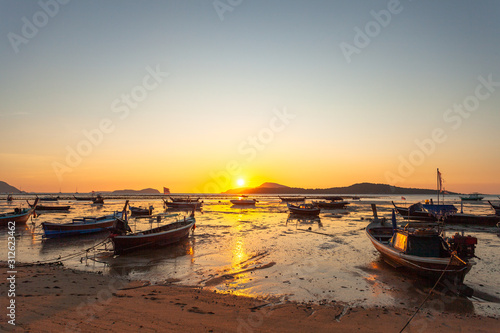 scenic reflection of beautiful sunshine in the sea fishing boats are floating in the Rawai sea