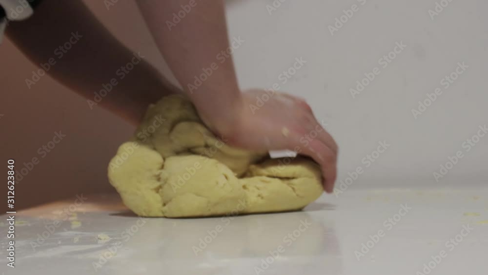 Making tradtional polish dumplings - woman kneading lump of dough for dumplings on a table. Polish christmas cuisine. Making tradtional polish dumplings - woman kneading lump of dough for dumplings on a table. Polish christmas cuisine.