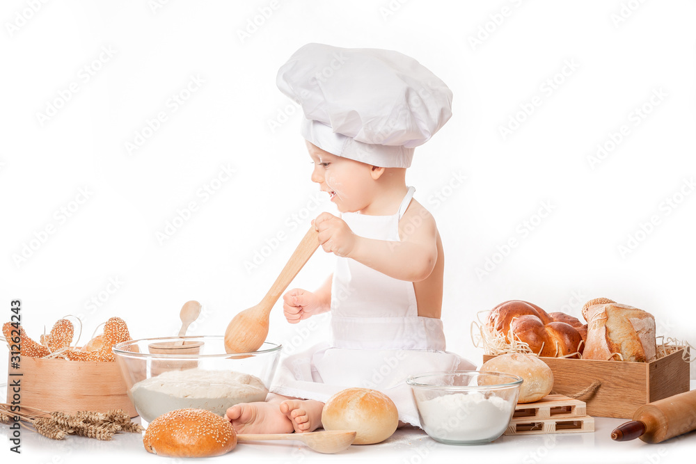 little boy in a cook costume among a baking bread rolls of flour confectionery. Copy space little boy in a cook costume among a baking bread rolls of flour confectionery. Copy space