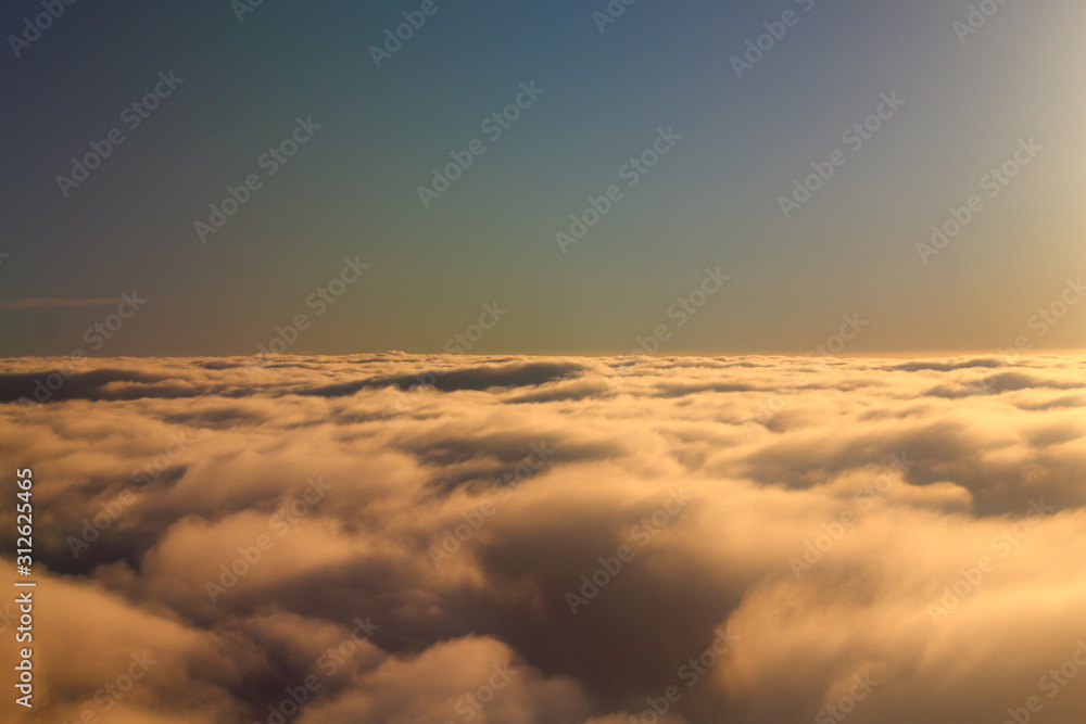 evocative image of white clouds with blue sky and sea in the background seen from a plane evocative image of white clouds with blue sky and sea in the background seen from a plane