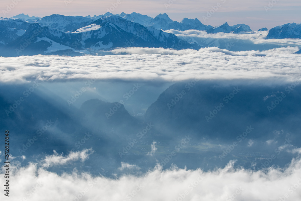 layer of clouds with tyndall effect at the flank of Mount Niesen at the entrance of Simmental Valley layer of clouds with tyndall effect at the flank of Mount Niesen at the entrance of Simmental Valley