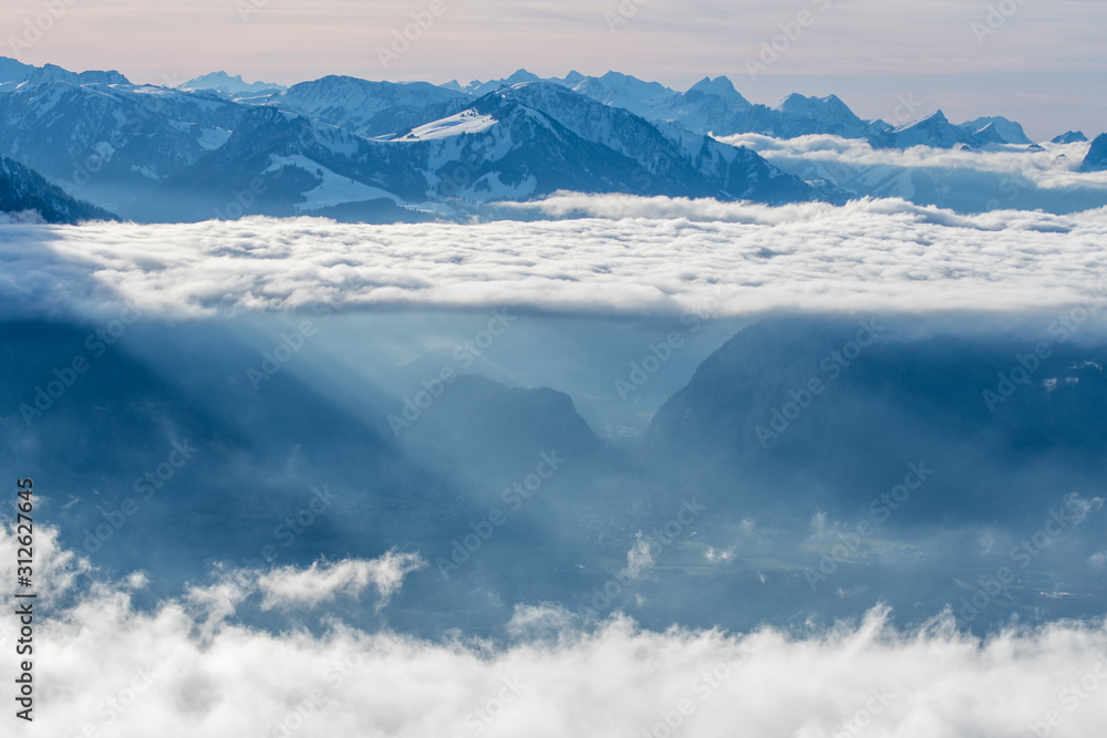 layer of clouds with tyndall effect at the flank of Mount Niesen at the entrance of Simmental Valley