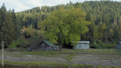 Aerial: Farm and barn along the Lochsa river in a forest.  Nez Perce Clearwater National Forests, Idaho, USA. 6 October 2019 photo