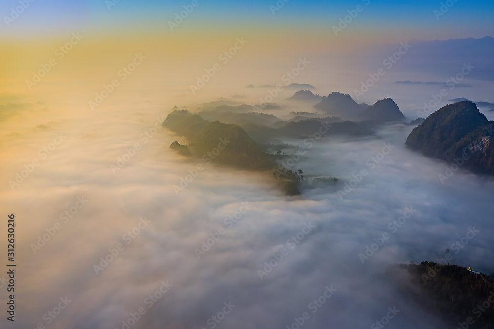 Top aerial view of the scenery landscape of mist and foggy flowing in between the mountains hills forest in the morning, autumn mist of the hills mountains, northern part of Thailand travel.