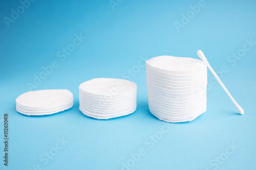 Hygiene discs and pads. White hygiene stack of disc on a blue background. Skincare mockup for design. Stack of disposable napkins. Cosmetology concept.