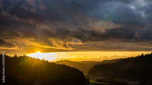 Germany  Magical orange sunset sky over beautiful black forest nature landscape valley with sunrays creating mystical mood