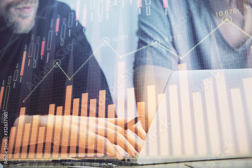 Forex graph with businessman typing on computer in office on background. Concept of analysis. Double exposure.