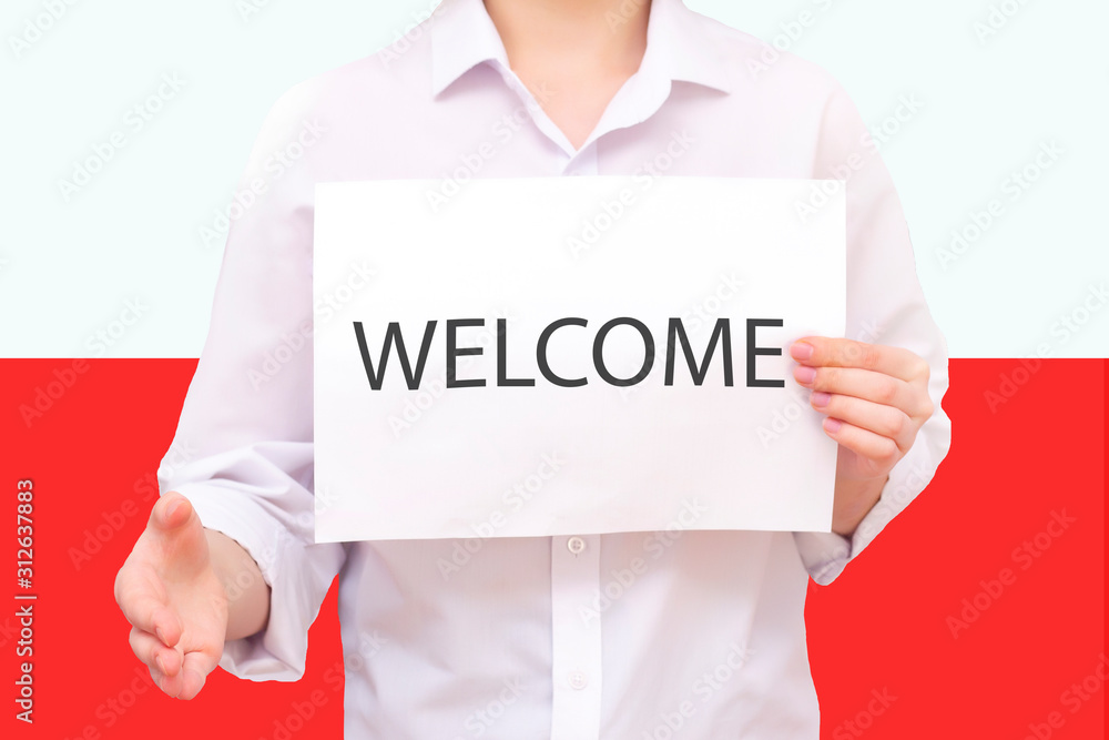 man with a white sheet of paper in his hands, with the inscription welcome. Against the background of the flag of Poland. Unknown person. He reaches out for agreement. man with a white sheet of paper in his hands, with the inscription welcome. Against the background of the flag of Poland. Unknown person. He reaches out for agreement.