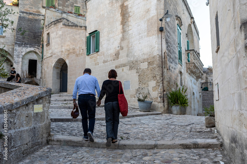  Couple during a walk on Cobblestone street in the Sassi di Matera a historic district in the city of Matera. Basilicata. Italy