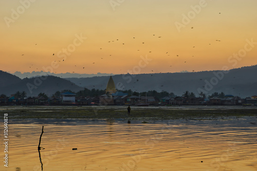 Sunset in Desa Bugis, facing Desa Sangia. Indonesia, Lima, West Nusa Tengara. Lake with mosque in Background. photo