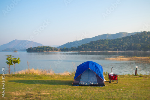 Tropical beautiful landscape view of Tent camping in National Park with lake and mountain in background.