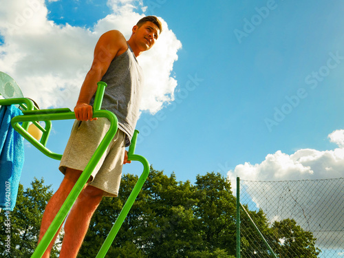 Man doing legs exercises in outdoor gym