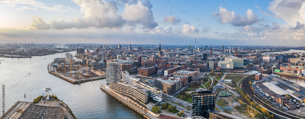Aerial drone panoramic view of port of Hamburg from above before sunset with dramatic stormy clouds over the sea port