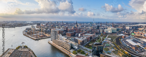Aerial drone panoramic view of port of Hamburg from above before sunset with dramatic stormy clouds over the sea port