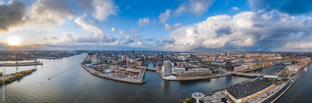 Aerial drone panoramic view of port of Hamburg from above before sunset with dramatic stormy clouds over historical city center