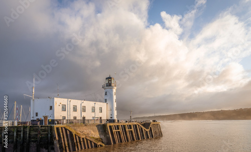 Lighthouse under a heavy cloud. photo