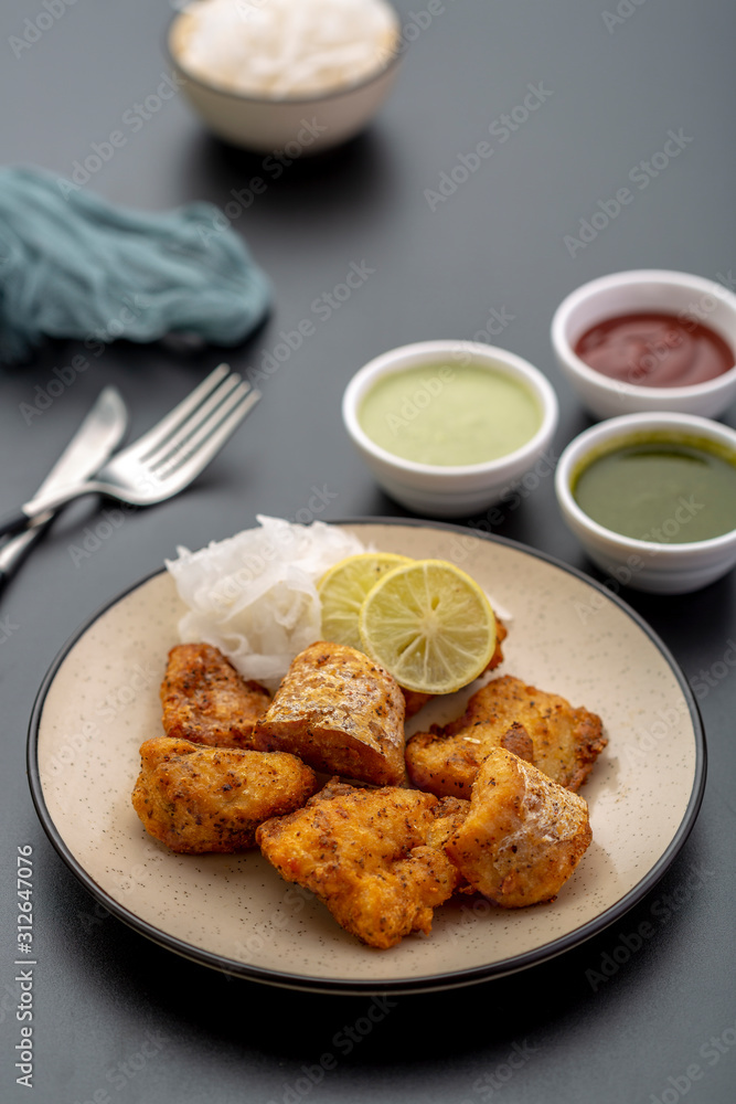 Boneless fried fish served with green sauce and dip Boneless fried fish served with green sauce and dip