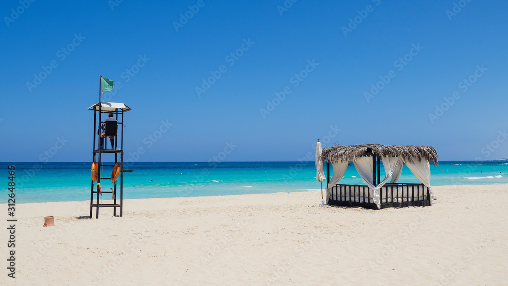 Marsa Matruh, Egypt. Gazebo on the beach. Lifeguard tower. Amazing sea with tropical blue, turquoise and green colors. Relaxing context. Fabulous holidays. Mediterranean Sea. Africa Marsa Matruh, Egypt. Gazebo on the beach. Lifeguard tower. Amazing sea with tropical blue, turquoise and green colors. Relaxing context. Fabulous holidays. Mediterranean Sea. Africa
