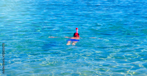 A child swims in a mask in the sea, kid activity