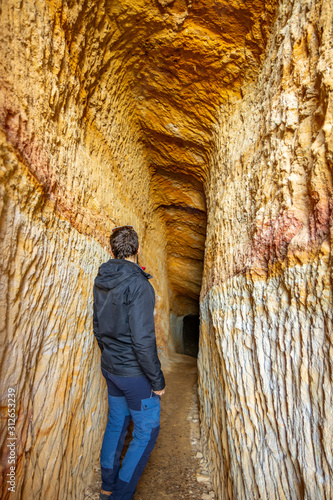 Fototapeta Naklejka Na Ścianę i Meble -  Excursionista en cueva estrecha excavada en caliza