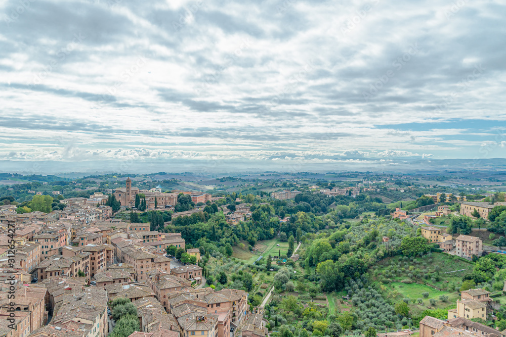 Beautiful aerial panoramic view of Old Town of medieval city of Siena in the cloudy autumn day, Tuscany, Italy