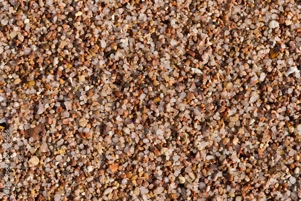 Small pebbles form the background of the sea shore. Coarse multicolor sand. Small pebbles form the background of the sea shore. Coarse multicolor sand.