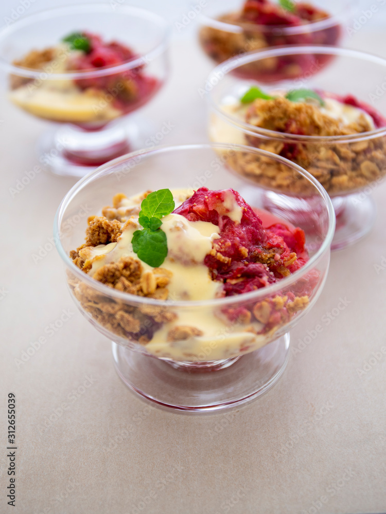 Fresh bright red plum crumble in the dessert bowl Fresh bright red plum crumble in the dessert bowl
