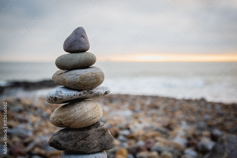Stack of stones against blurred seascape on a beach swansea wales, space for text. Zen concept