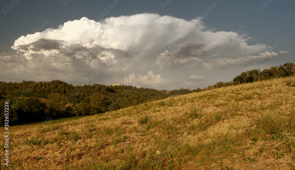 Cumulus clouds building over the Tuscan landscape