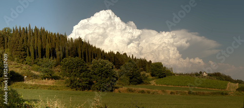 Cumulus clouds building over the Tuscan landscape photo