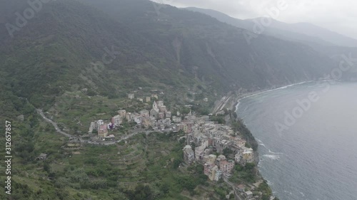Wallpaper Mural Aerial footage of Corniglia village on rocky coast.  Colorful italian houses, church, green mountains and blue sea. Cinque Terre, Italy.  Torontodigital.ca