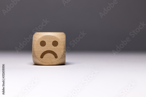 Pictogramme smiley triste sur cube en bois