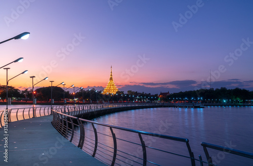 Foto In Khon kaen twilight time at Bueng Kaen nakhon with Wat Phra Mahathat Kaen Nakhon, travel concept, lifestyle with copy space
