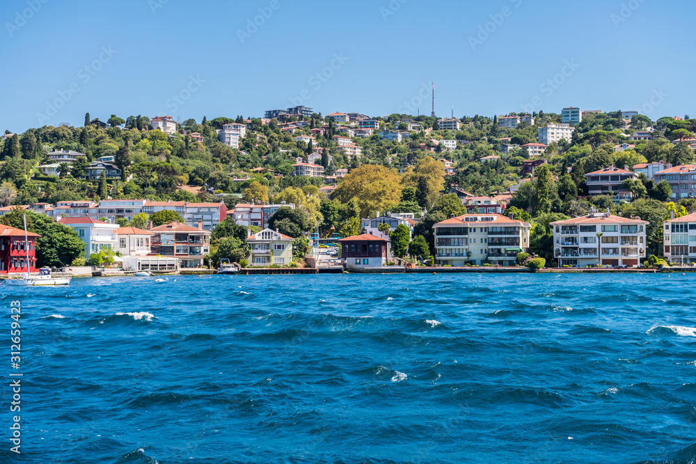 Beautiful builings and mansions at the costline and hillslope with green forest in summer, at Bosphorus Strait in Istanbul,Turkey. View from a Cruise Ship.