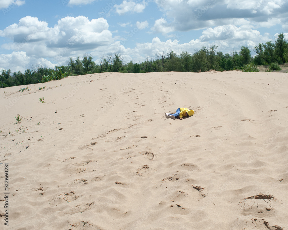 The traveler is tired and lies on the sand. Exhausted The traveler is tired and lies on the sand. Exhausted