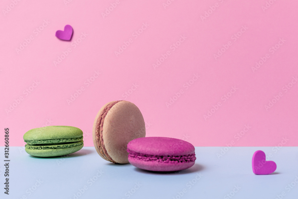 Beige and red, green macaroons with hearts are on a light background. Greeting card Valentine's day. Copy space. Beige and red, green macaroons with hearts are on a light background. Greeting card Valentine's day. Copy space.