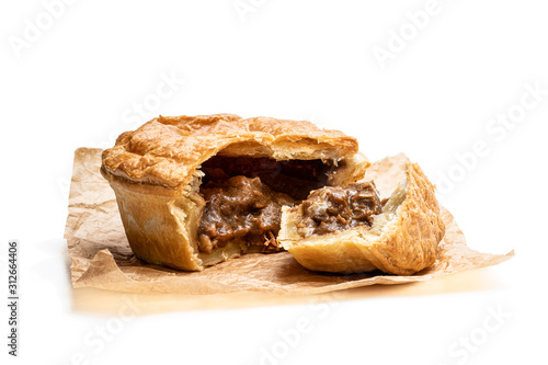 Bild auf Leinwand Puff pastry steak pie on baking paper isolated on white