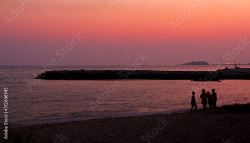 silhouette of people on beach at sunset