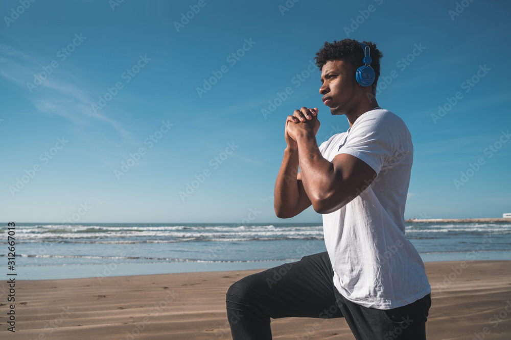 Athletic man doing exercise at the beach.
