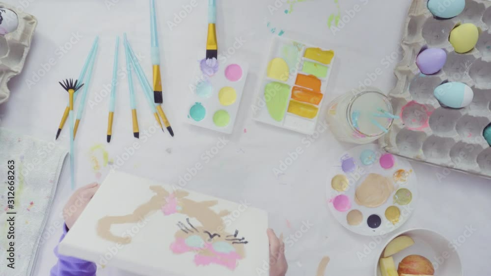 Flat lay. Little girl and her mom painting Easter art project with acrylic paint. Flat lay. Little girl and her mom painting Easter art project with acrylic paint.