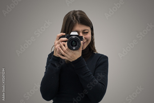 Elegant caucasian pretty girl taking a picture with mirrorless camera.