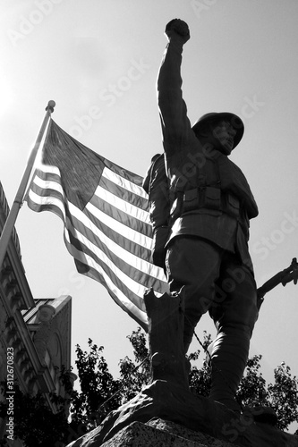 The Doughboy Viquesney WWII World War 2 Monument in Black and White with American Flag in Background in Polk County Bolivar Missouri MO