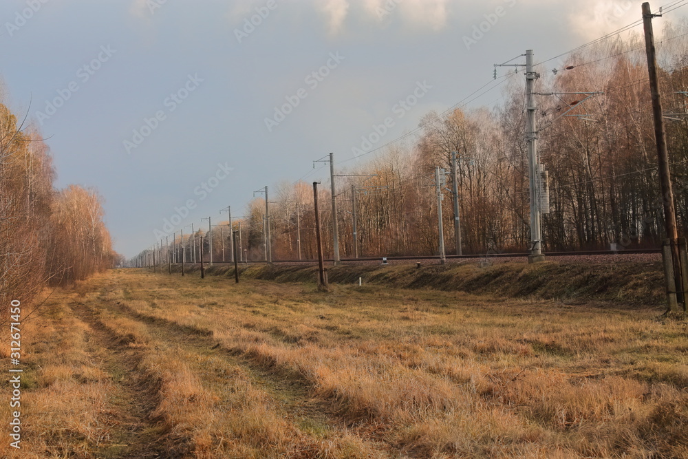autumn rural road along the railway. the road on which rarely goes transport. autumn rural road along the railway. the road on which rarely goes transport.