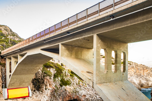 The Ciolo bridge, which connects two high cliffs, in an inlet of the sea, in Gagliano del Capo, near Santa Maria di Leuca, in Salento. In the evening, at sunset, in the winter. Puglia, Italy. photo