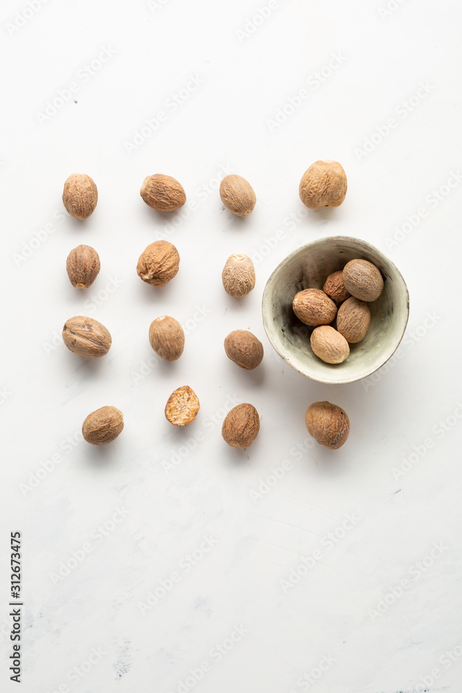 Aromatic nutmeg in bowl top view, food pattern