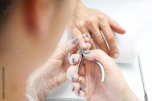 Cutting cuticles  manicure. Woman at the beauty salon