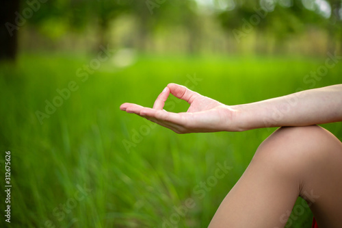 A young sports girl practices yoga in a quiet location on the river bank in summer, in a yoga asana pose. Meditation and oneness with nature © Kate