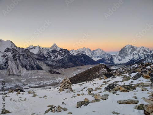 Taboche, Kangtega and Ama Dablam mountain peaks rises above Khumbu glacier and valley covered with clouds in the early morning in Himalayas. Theme of trekking in Nepal. Clear sunrise sky.