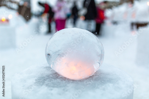 Ice lantern with candle burning inside