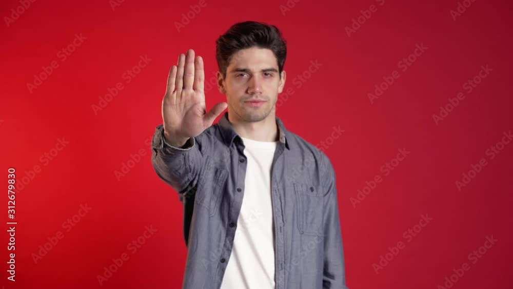 No, never, handsome brunette man disliking and rejecting gesture by stop sign. Portrait of young successful confident guy isolated on red background. No, never, handsome brunette man disliking and rejecting gesture by stop sign. Portrait of young successful confident guy isolated on red background.
